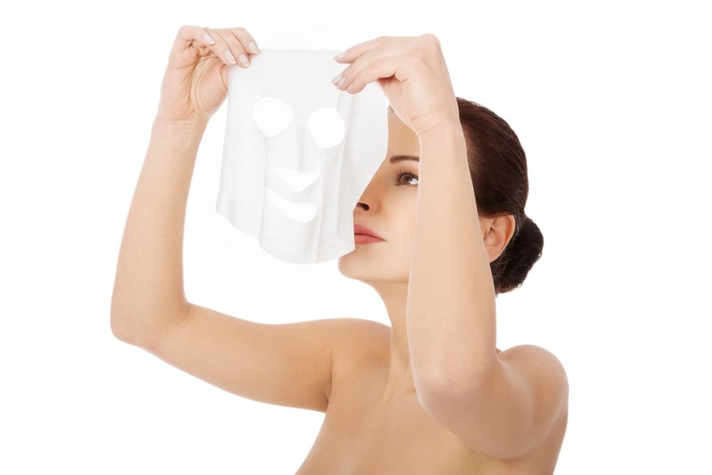 Woman putting mask on face