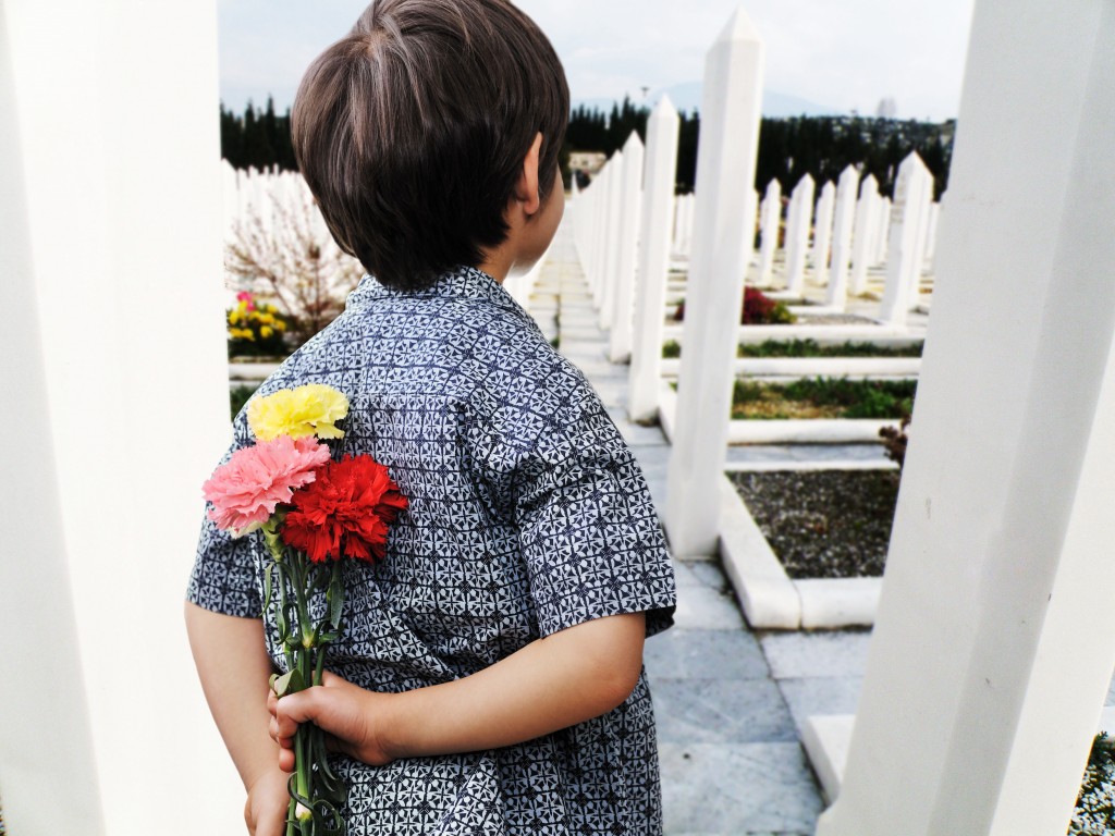 Kid holding flowers at the cemetery