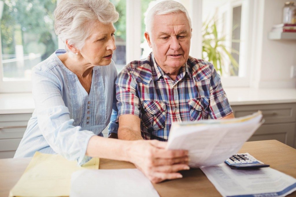 Elderly couple computing their expenses
