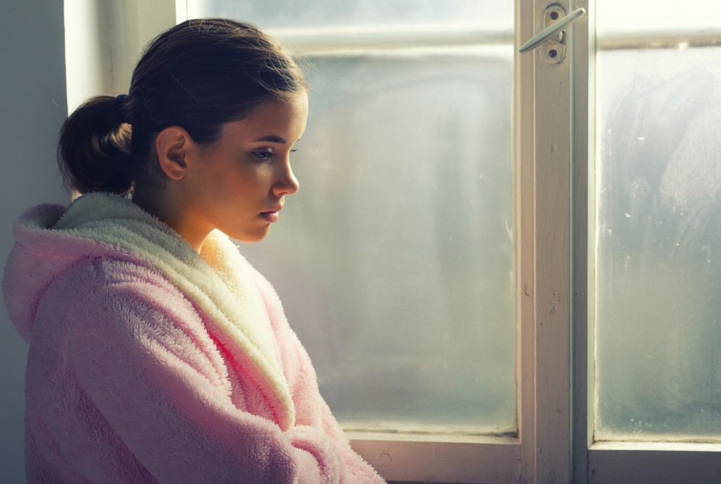 Depressed teenager beside the window