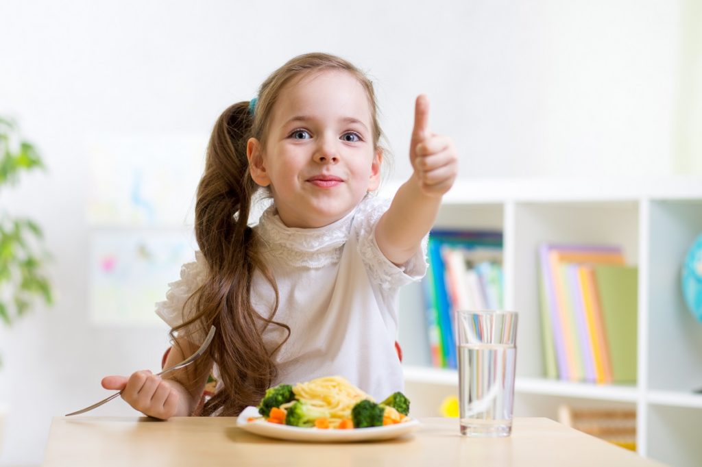 Eating child doing a thumbs up