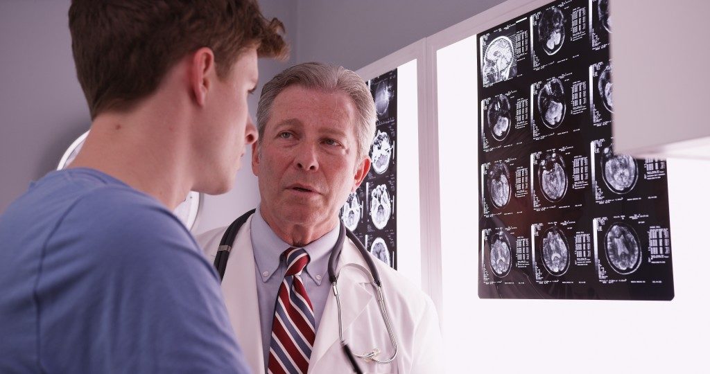 man with serious concussion, checks MRI results