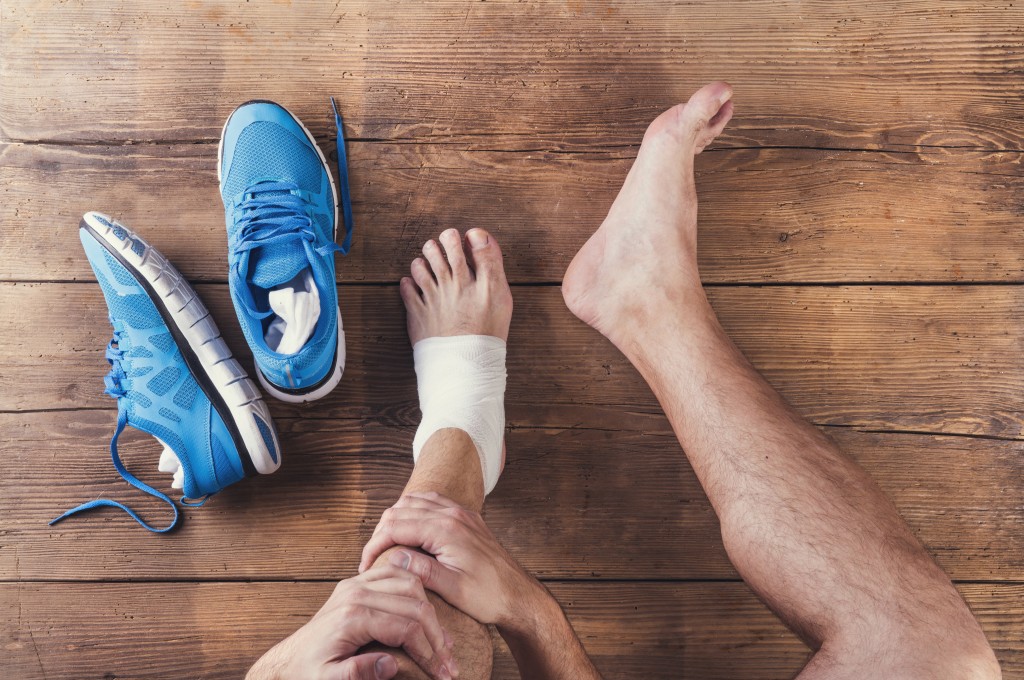 injured runner sitting on a wooden floor background