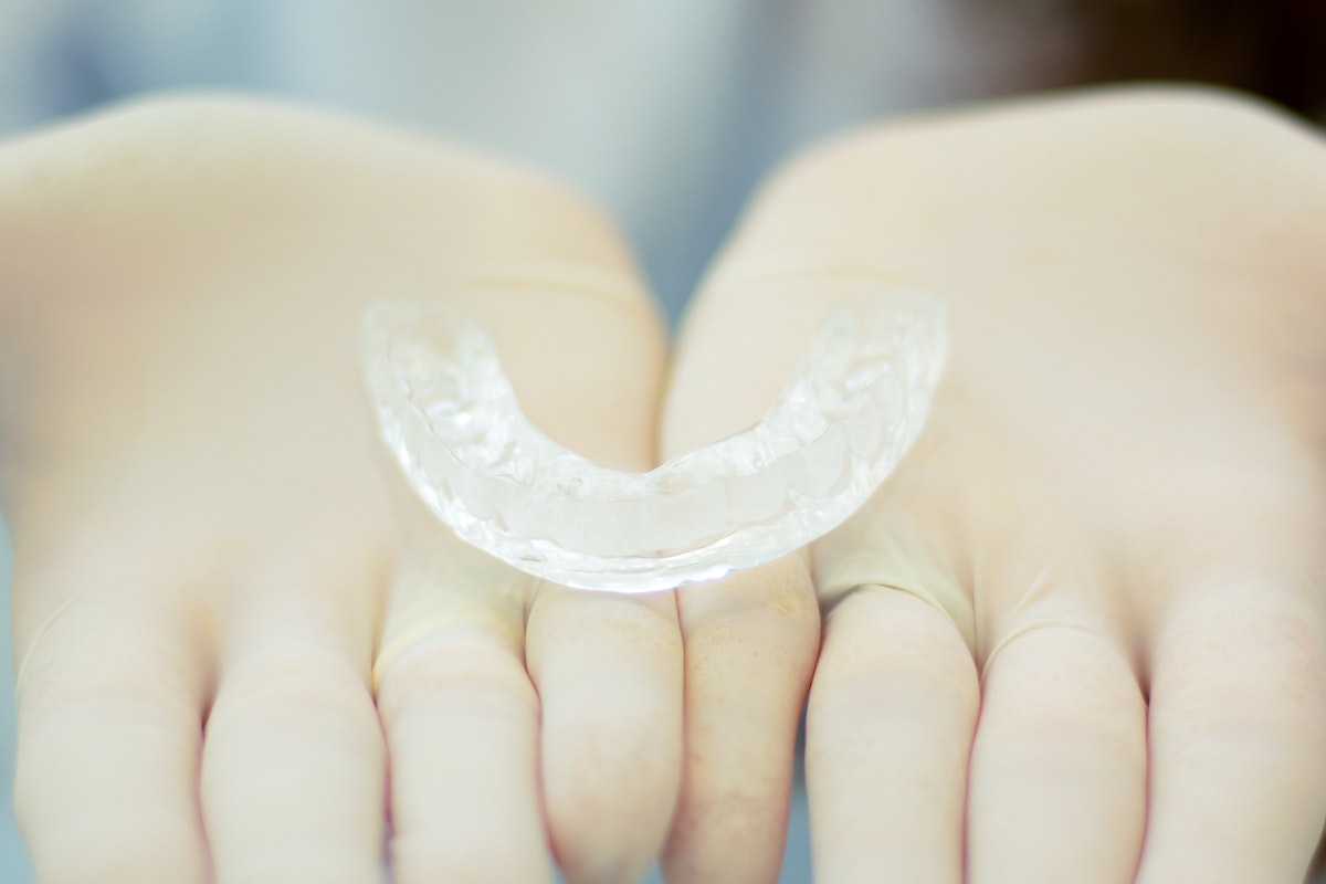 clear aligners in both hands