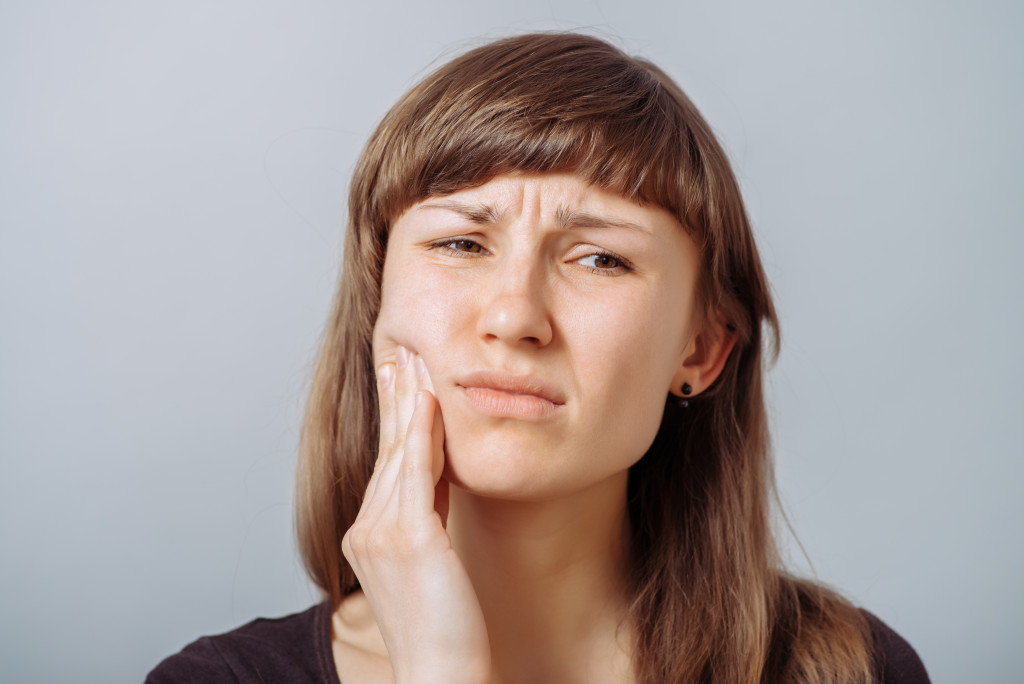 A woman experiencing jaw or toothache
