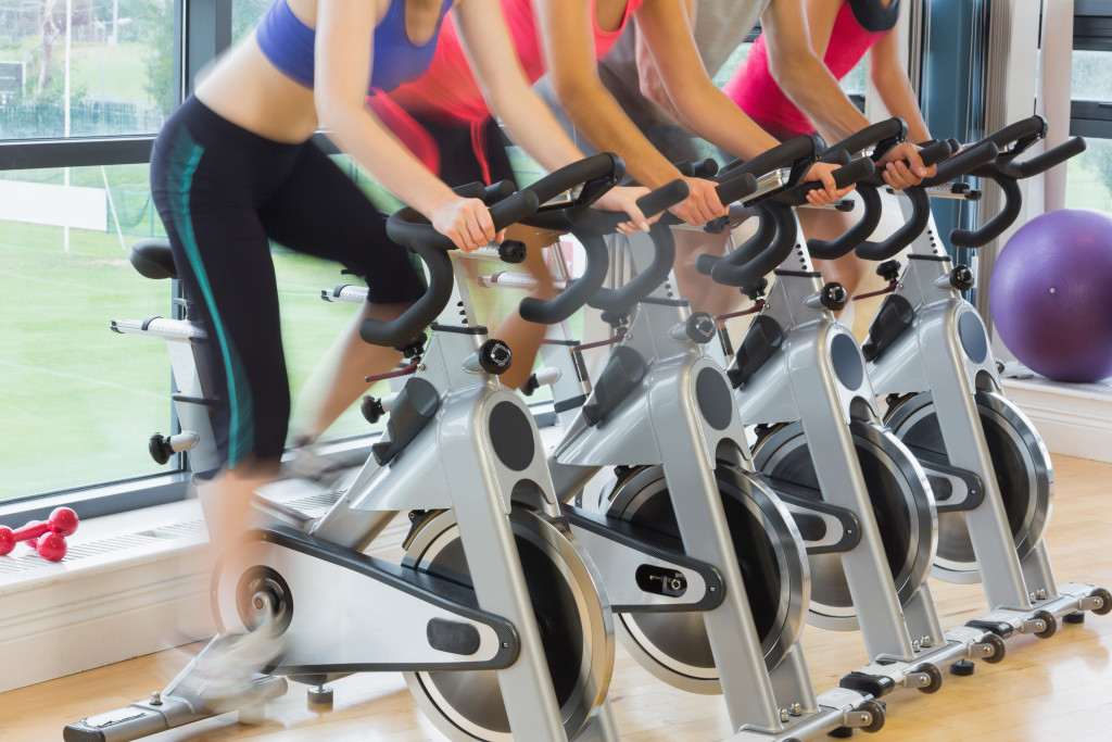 women exercising at a bike machine at the gym