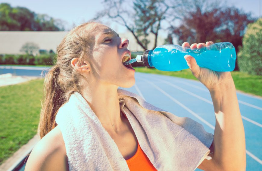 athlete drinking liquid under the sun